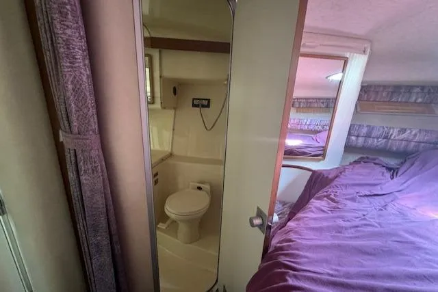 Slide: The Image of Interior of 1990 Sea Ray 350 Sundancer with bathroom and cozy sleeping area. - 14
