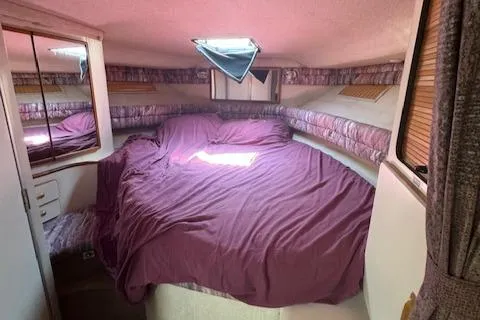 Slide: The Image of Cozy cabin interior of 1990 Sea Ray 350 Sundancer with purple bedding. - 15