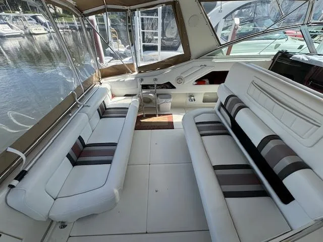 Slide: The Image of Interior of 1990 Sea Ray 350 Sundancer with white seating and striped cushions. - 2