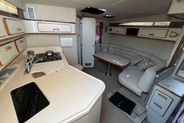 Slide: The Image of Interior of 1990 Sea Ray 350 Sundancer yacht with kitchen and seating area. - 23