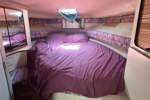 Slide: The Image of Interior cabin of 1990 Sea Ray 350 Sundancer with purple bedding. - 24