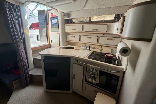 Slide: The Image of Interior of 1990 Sea Ray 350 Sundancer yacht with compact kitchen and storage cabinets. - 7