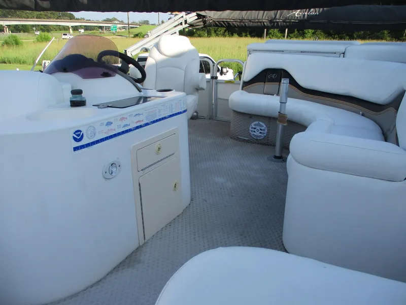 Slide: The Image of Interior of 2007 Avalon Excalibur 27' boat with white seating and helm. - 17