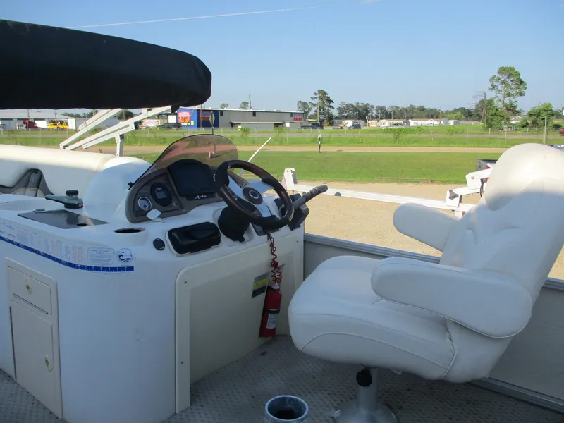 Slide: The Image of 2007 Avalon Excalibur boat helm with white captain's chair and steering wheel. - 18