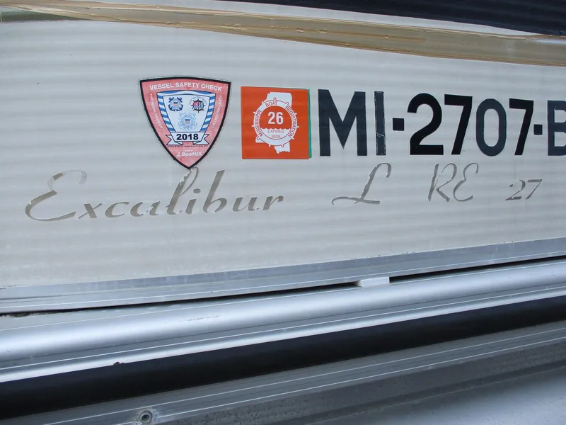 Slide: The Image of Close-up of 2007 Avalon Excalibur boat registration and safety stickers. - 22