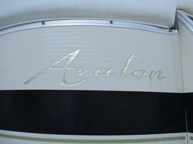 Slide: The Image of Avalon Excalibur 27' 2007 boat logo on a sleek, metallic surface. - 23