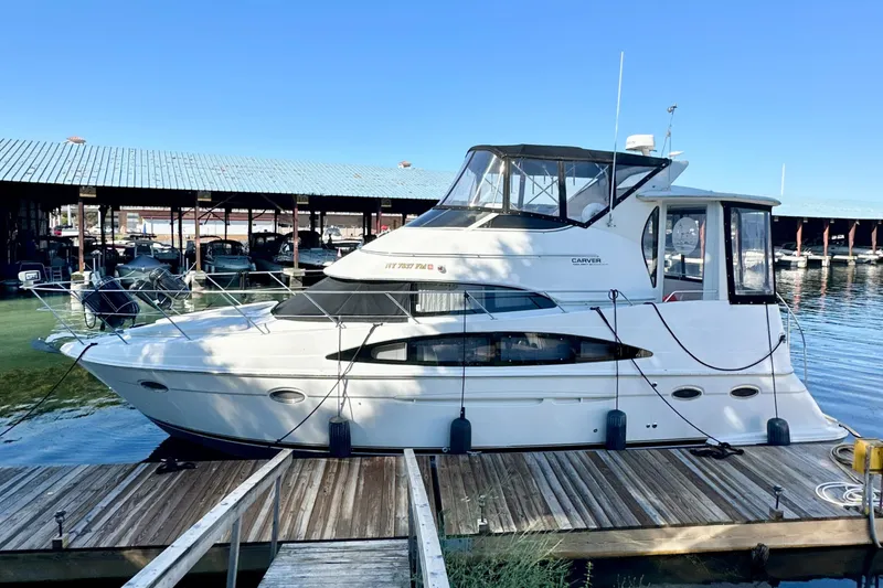 Slide: The Image of 2000 Carver 396 Motor Yacht docked at marina under clear blue sky. - 0
