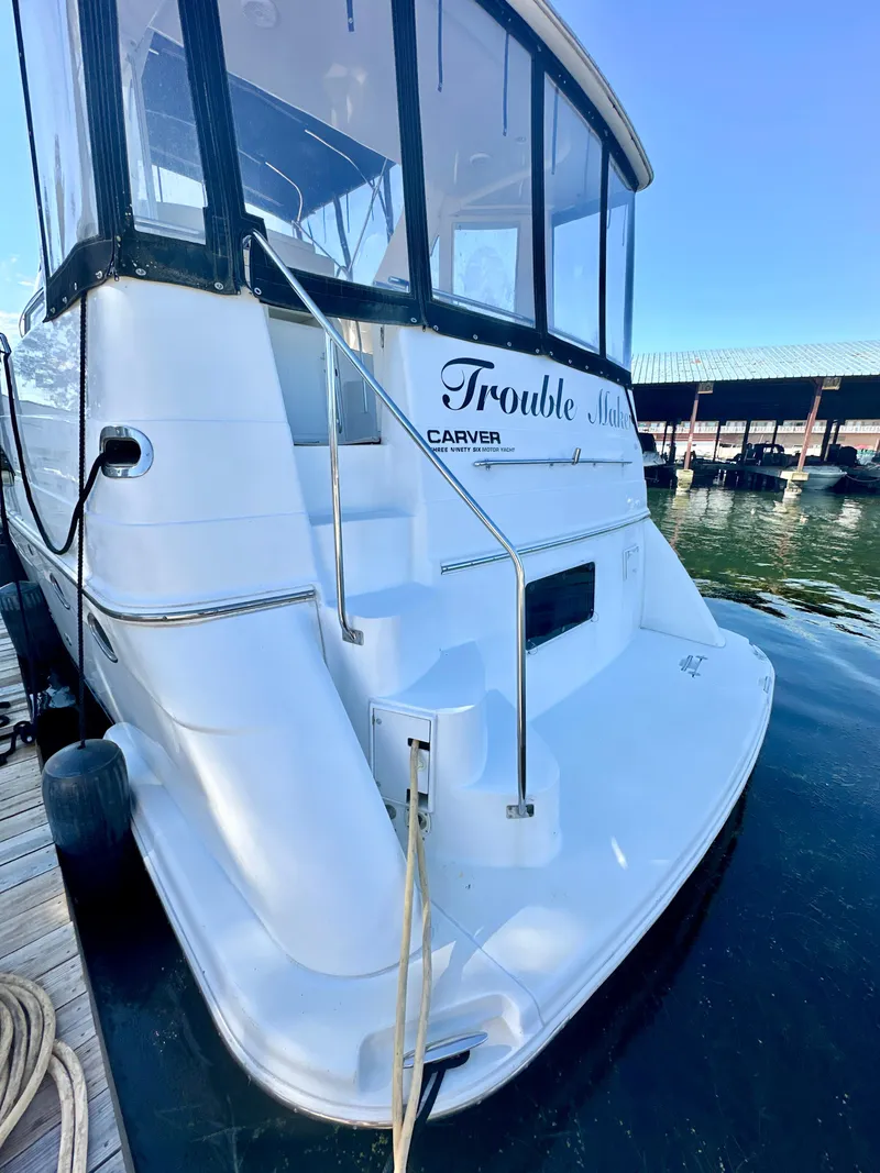 Slide: The Image of 2000 Carver 396 Motor Yacht docked, rear view with "Trouble" name visible. - 2