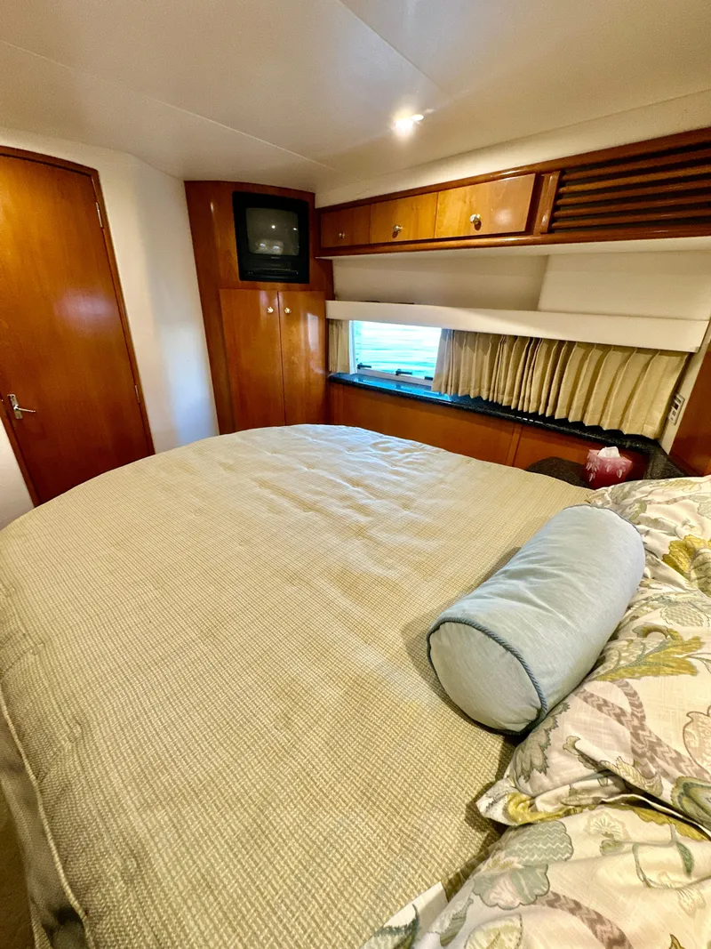 Slide: The Image of Interior of 2000 Carver 396 Motor Yacht bedroom with cozy bed and wooden cabinetry. - 29