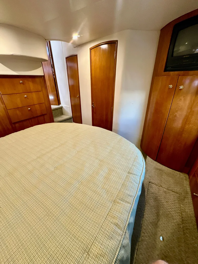Slide: The Image of 2000 Carver 396 Motor Yacht bedroom with wood cabinets and TV. - 30