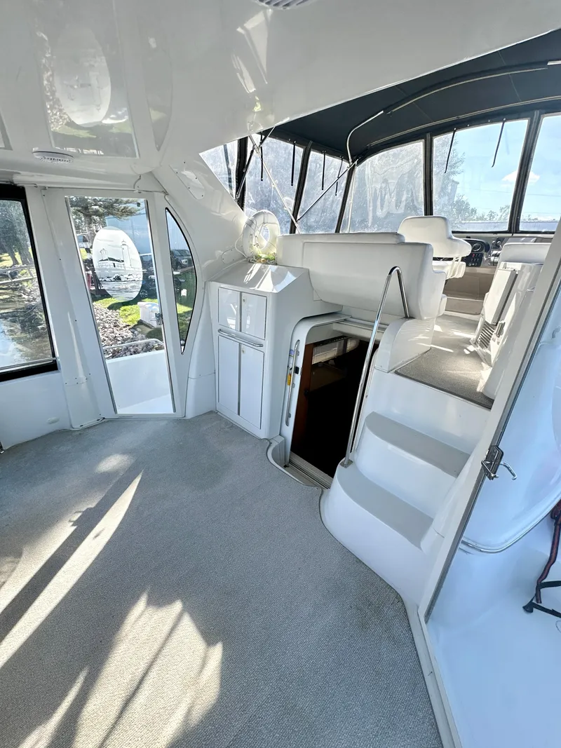 Slide: The Image of 2000 Carver 396 Motor Yacht interior with stairs, seating, and large windows. - 6