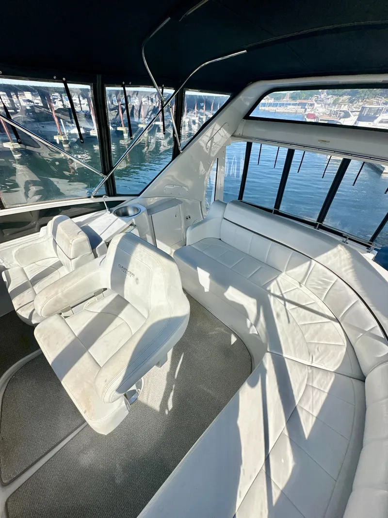 Slide: The Image of Interior of 2000 Carver 396 Motor Yacht with white seating and marina view. - 11