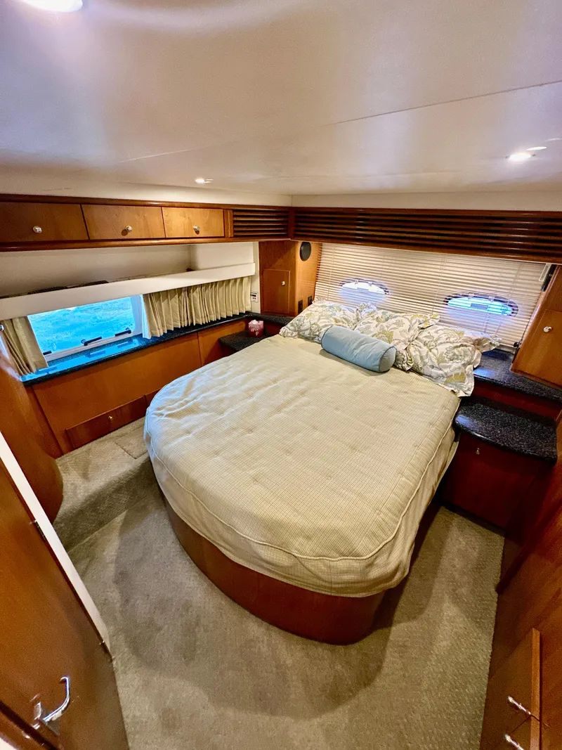 Slide: The Image of Luxurious bedroom interior of 2000 Carver 396 Motor Yacht with cozy bed and wooden cabinetry. - 31