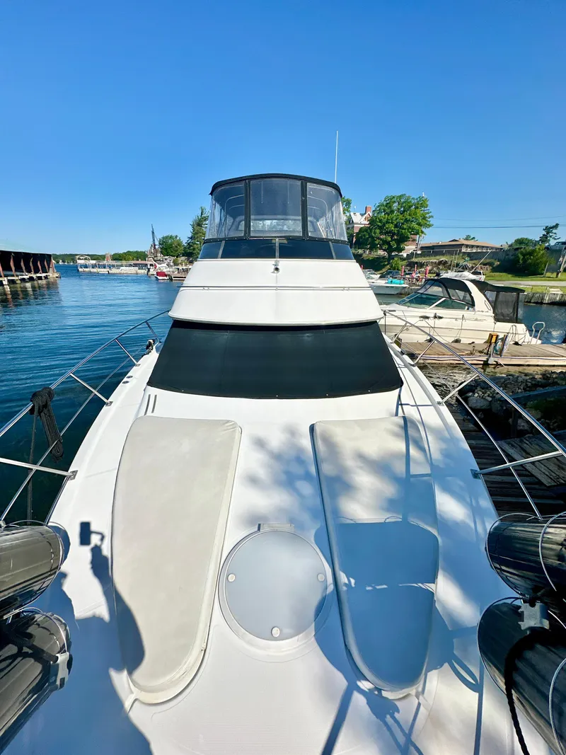 Slide: The Image of 2000 Carver 396 Motor Yacht docked, showcasing sleek design and spacious deck under clear blue sky. - 4