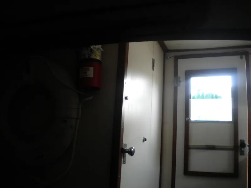 Slide: The Image of Interior view of a 1968 Bertram 31 Bahia Mar boat cabin with door and window. - 17