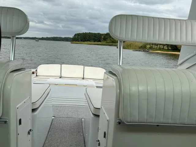 Slide: The Image of 1968 Bertram 31 Bahia Mar boat interior with white seating, overlooking a serene lake. - 27
