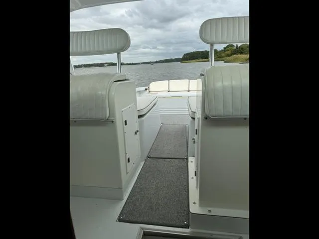 Slide: The Image of 1968 Bertram 31 Bahia Mar boat interior with white seating, overlooking a serene water view. - 28