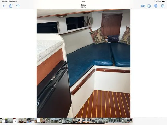 Slide: The Image of Interior of a 1968 Bertram 31 Bahia Mar boat with blue seating and wooden flooring. - 31