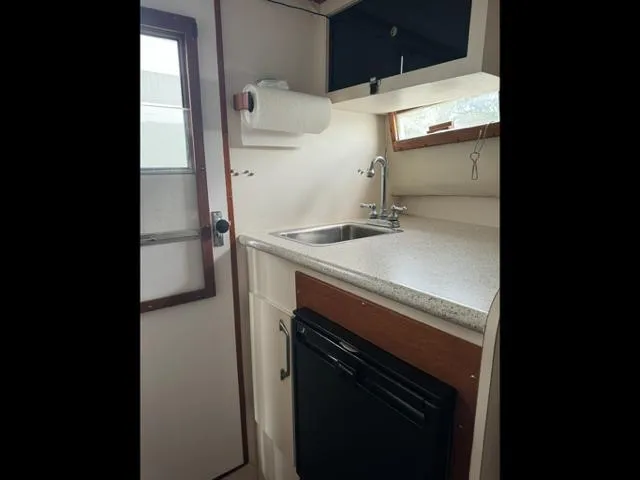 Slide: The Image of 1968 Bertram 31 Bahia Mar boat interior kitchen with sink, countertop, and storage. - 32
