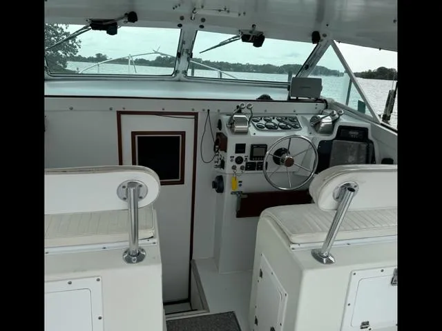 Slide: The Image of 1968 Bertram 31 Bahia Mar boat cockpit with steering wheel and control panel. - 34