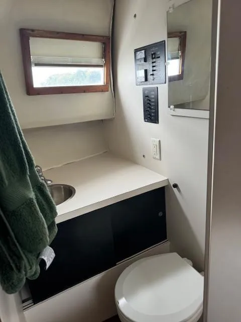 Slide: The Image of 1968 Bertram 31 Bahia Mar boat bathroom with sink, toilet, and window. - 38