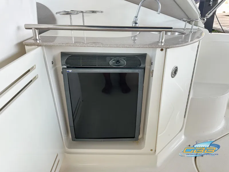 Slide: The Image of 2006 Sea Ray 290 Sundancer boat kitchenette with mini fridge and sink. - 22