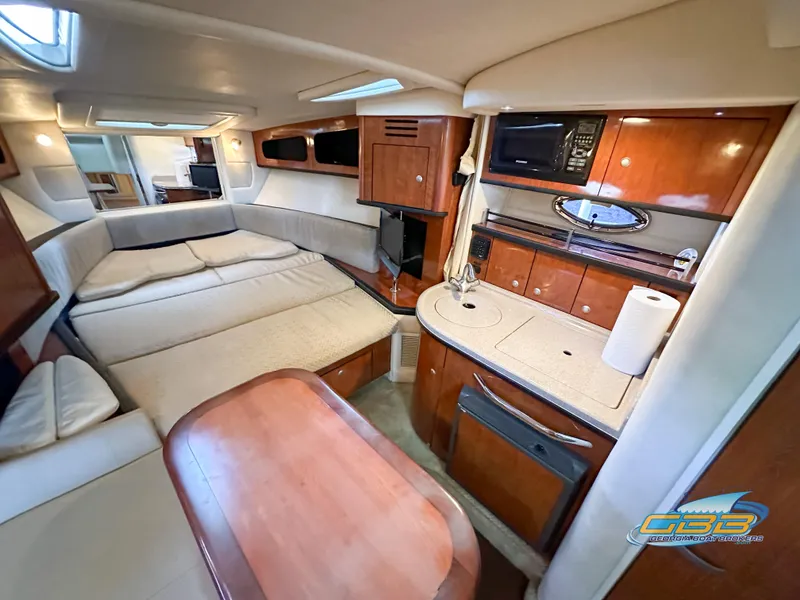 Slide: The Image of 2006 Sea Ray 290 Sundancer cabin interior with kitchenette, seating, and sleeping area. - 27