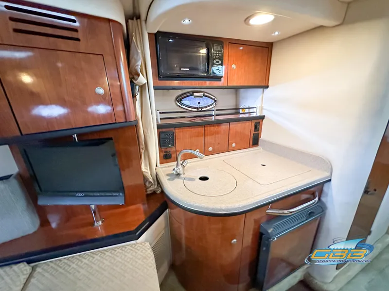 Slide: The Image of Interior of 2006 Sea Ray 290 Sundancer with kitchenette and wood cabinetry. - 30