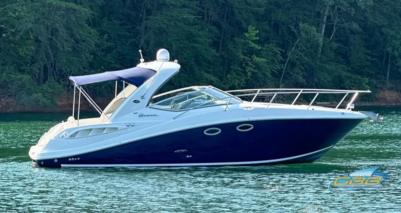 Slide: The Image of 2006 Sea Ray 290 Sundancer boat on a serene lake with forest backdrop. - 5