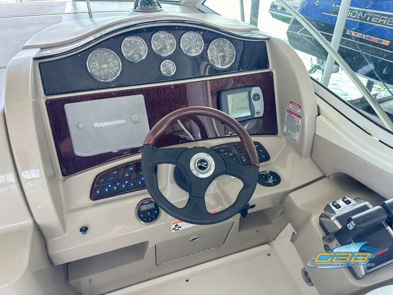 Slide: The Image of 2006 Sea Ray 290 Sundancer helm with Raymarine navigation and wood-accented dashboard. - 8