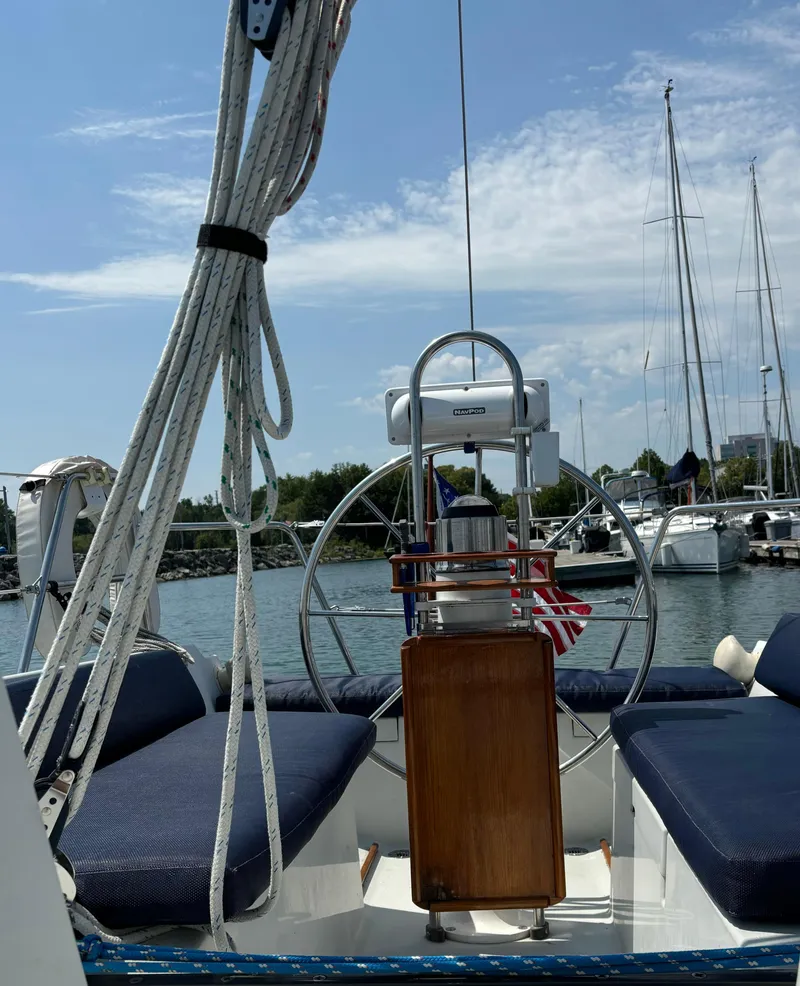 Slide: The Image of 1989 Ericson Yachts 34 sailboat cockpit with steering wheel and ropes, docked in marina. - 10