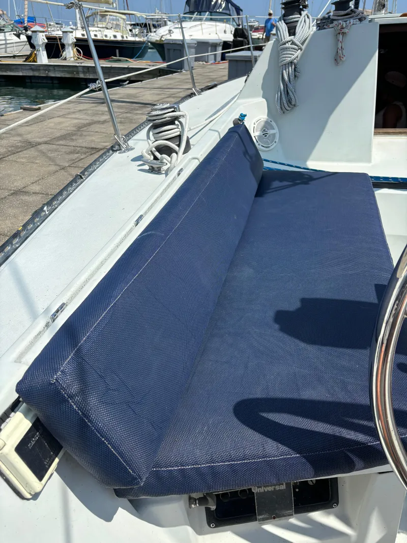 Slide: The Image of 1989 Ericson Yachts 34 sailboat cockpit with blue seating at marina. - 11
