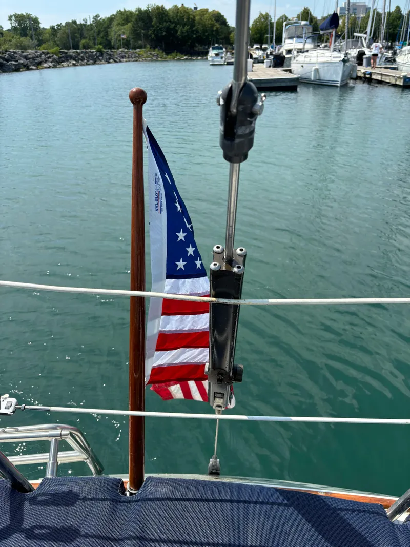 Slide: The Image of 1989 Ericson Yachts 34 with American flag in marina setting. - 18