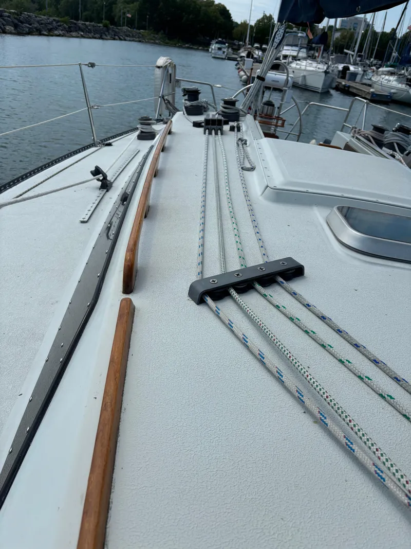Slide: The Image of 1989 Ericson Yachts 34 sailboat deck with rigging and marina background. - 22