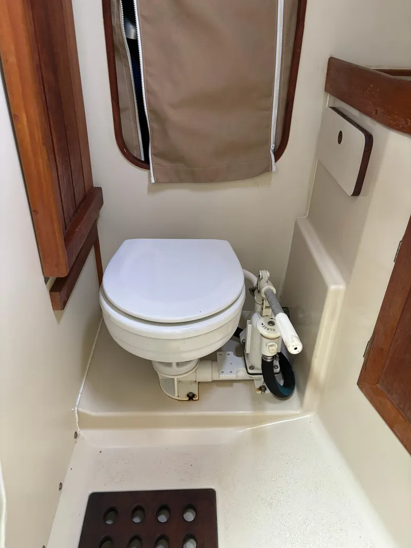 Slide: The Image of 1989 Ericson Yachts 34 marine toilet with wooden accents and compact design. - 27