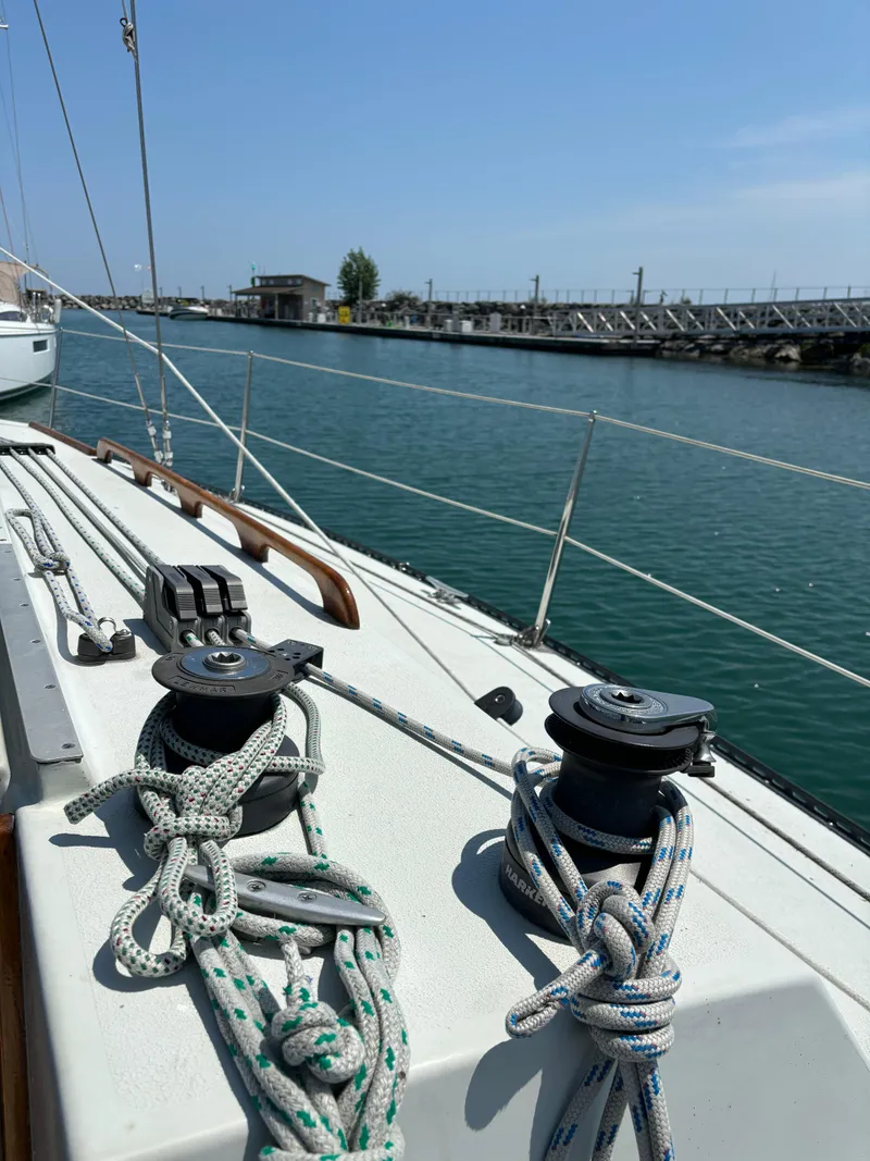 Slide: The Image of 1989 Ericson Yachts 34 sailboat deck with ropes and winches, dockside view. - 8