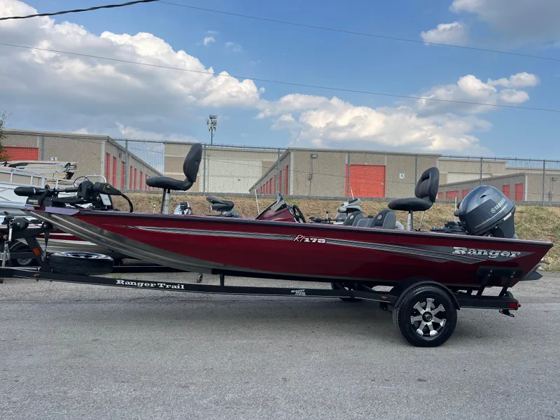 Slide: The Image of 2016 Ranger RT 178 Tournament Edition boat, red, parked outdoors under a cloudy sky. - 13