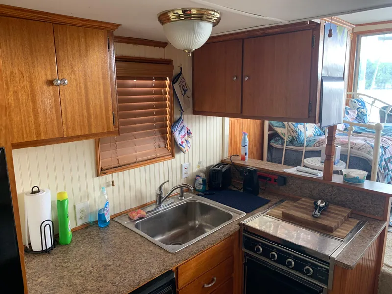 Slide: The Image of 1965 Lazy Days Custom kitchen with wood cabinets, sink, stove, and cozy interior. - 11