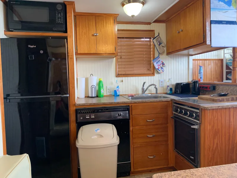 Slide: The Image of 1965 Lazy Days Custom kitchen with wooden cabinets, modern appliances, and compact design. - 12