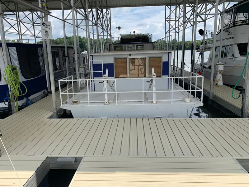 Slide: The Image of 1965 Lazy Days Custom houseboat docked at a marina under a metal canopy. - 2