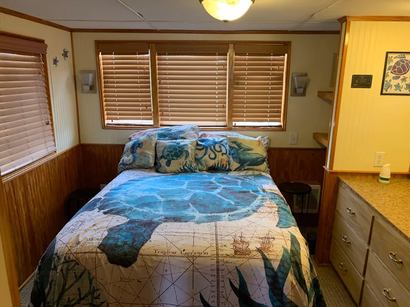 Slide: The Image of Cozy bedroom in 1965 Lazy Days Custom RV with nautical-themed bedding and wooden blinds. - 20