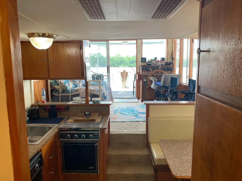 Slide: The Image of 1965 Lazy Days Custom houseboat interior with kitchen, dining area, and helm. - 22
