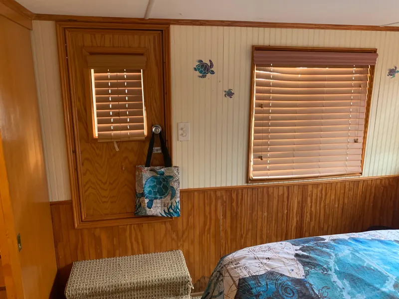 Slide: The Image of Cozy 1965 Lazy Days Custom interior with wood paneling, floral decor, and window blinds. - 23
