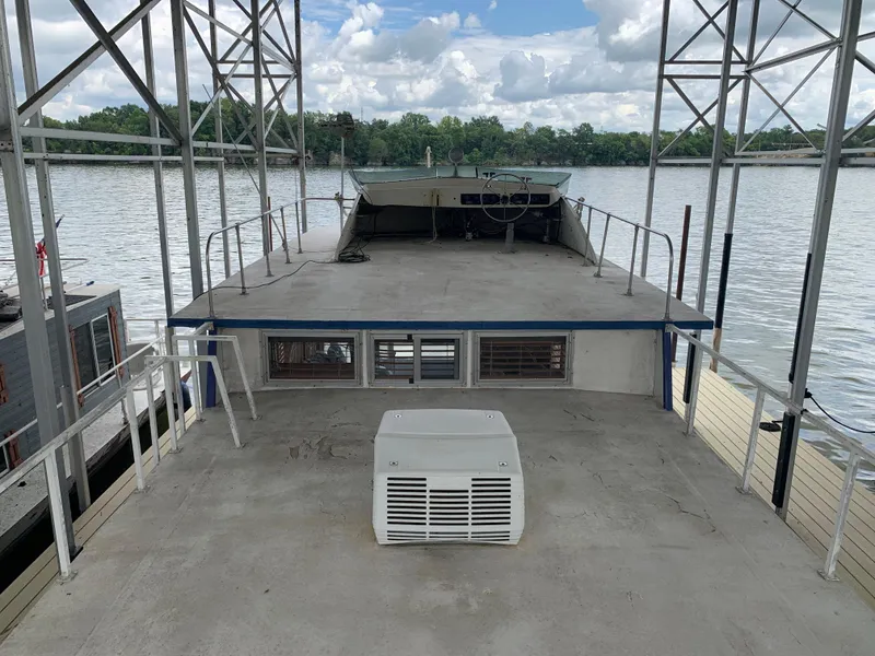 Slide: The Image of 1965 Lazy Days Custom houseboat docked on a calm river under a cloudy sky. - 28