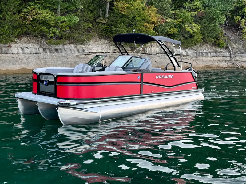 Slide: The Image of 2024 Premier 250 Solaris pontoon boat on a scenic lake with lush green shoreline. - 10