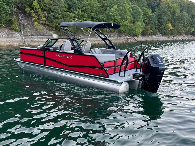 Slide: The Image of 2024 Premier 250 Solaris pontoon boat on a lake, featuring a red exterior and canopy. - 11
