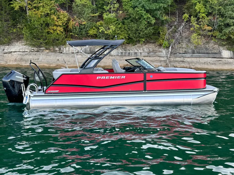 Slide: The Image of 2024 Premier 250 Solaris pontoon boat on a scenic lake with lush greenery. - 12