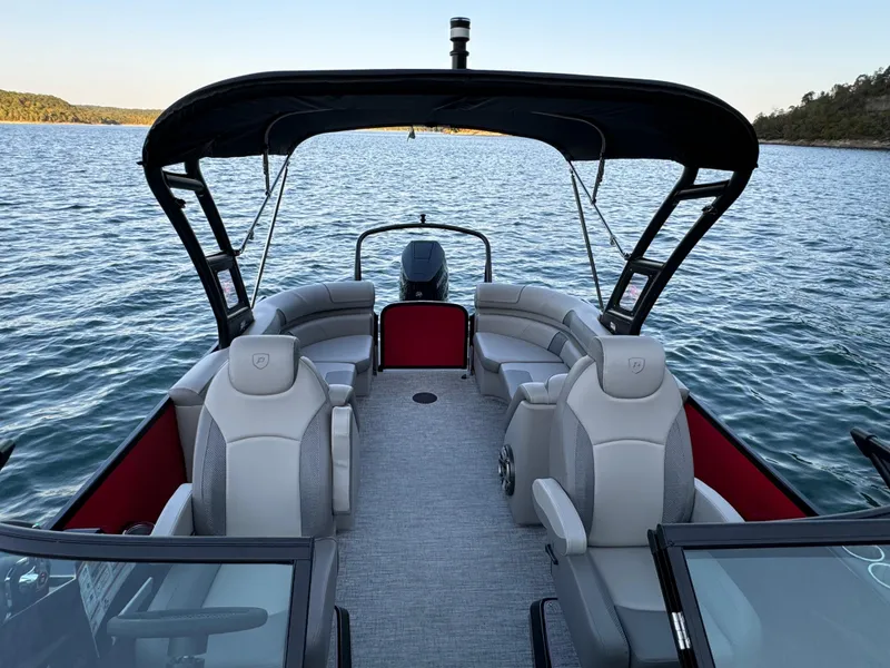Slide: The Image of 2024 Premier 250 Solaris pontoon boat on a serene lake, featuring spacious seating and modern design. - 15