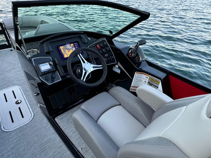 Slide: The Image of 2024 Premier 250 Solaris boat cockpit with modern controls and steering, overlooking water. - 21