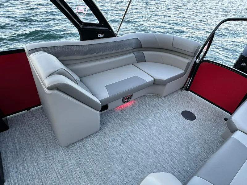 Slide: The Image of 2024 Premier 250 Solaris boat interior with gray seating and carpet, overlooking water. - 26